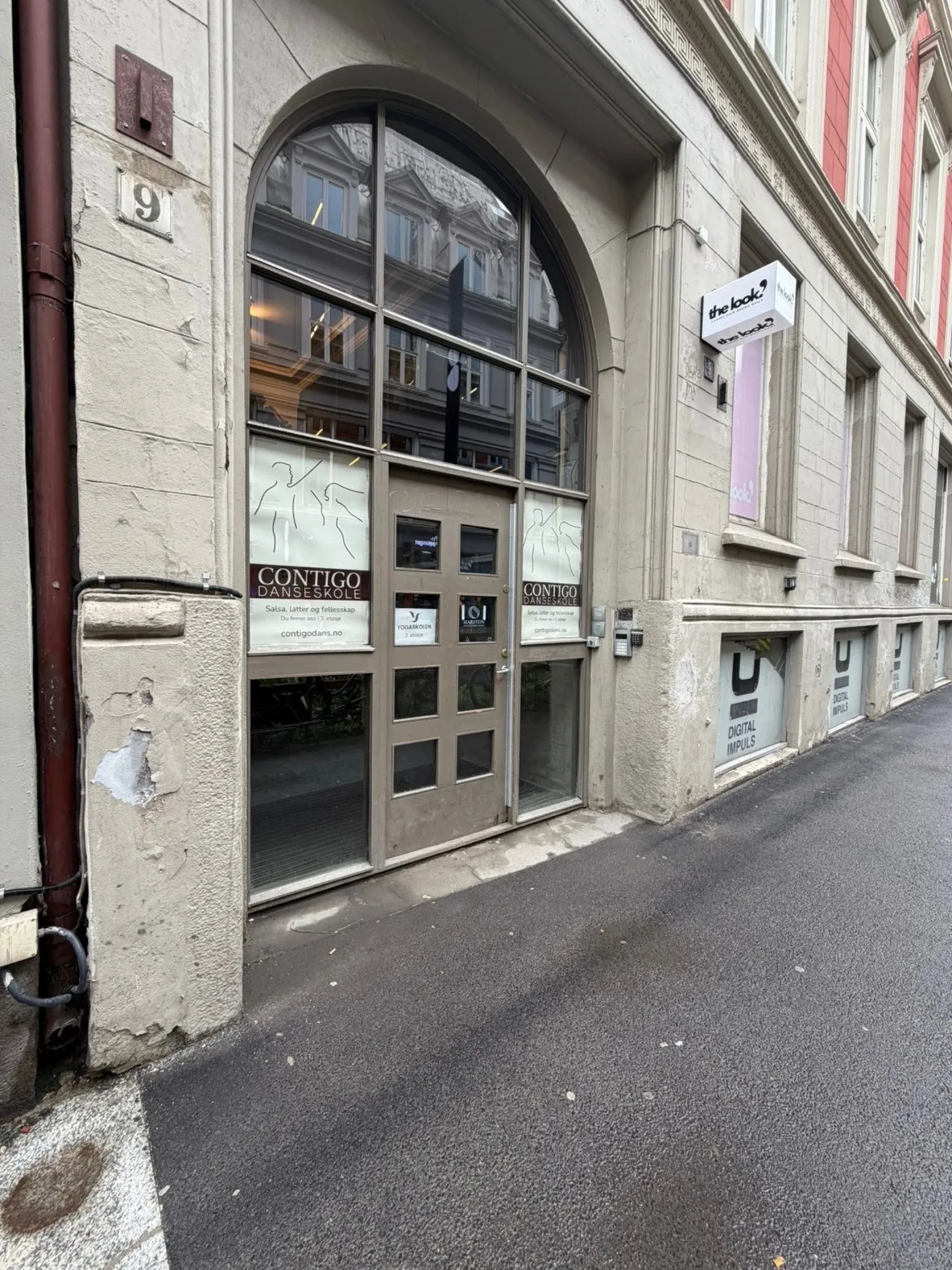 Porten i Møllergata 9 sett fra gaten, med klinikkens skilt på døren